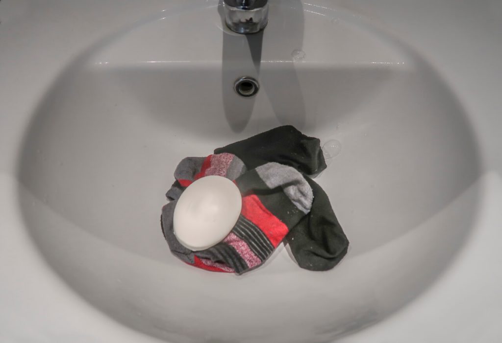 Backpackers washing clothes in the sink